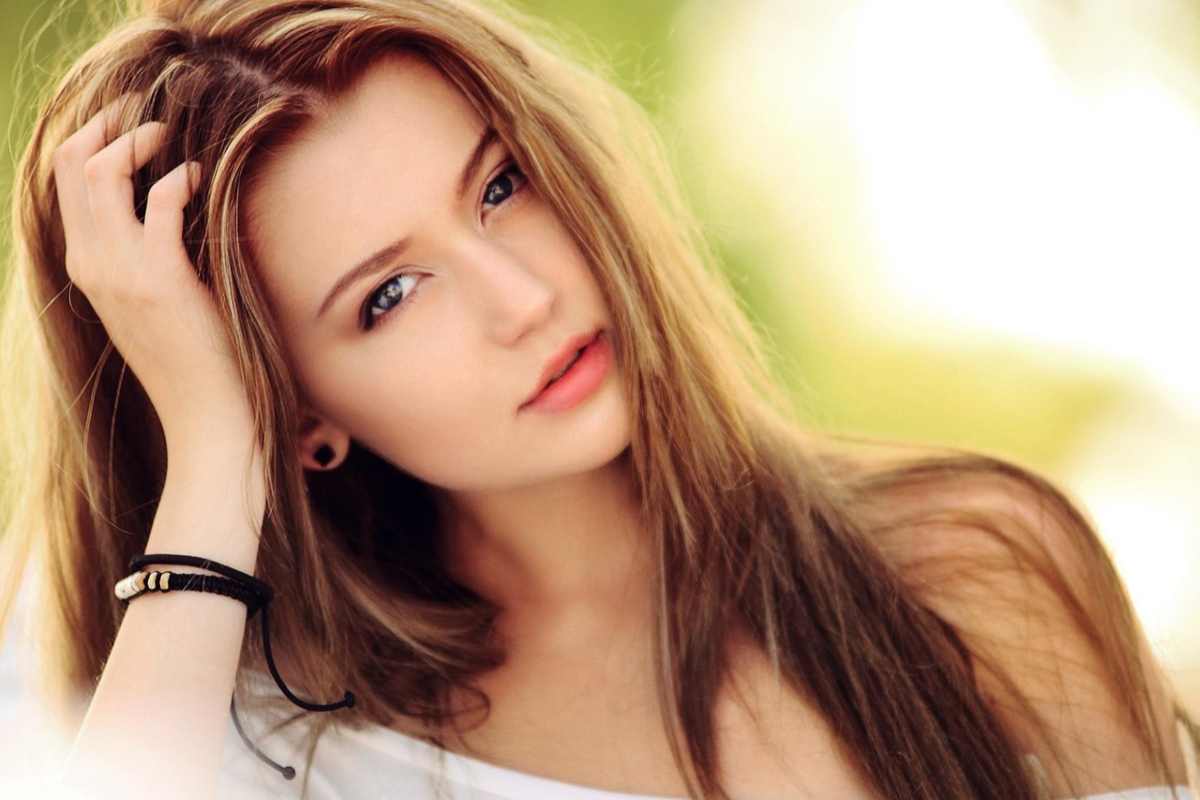 ragazza che si tocca i capelli sulla testa con una mano